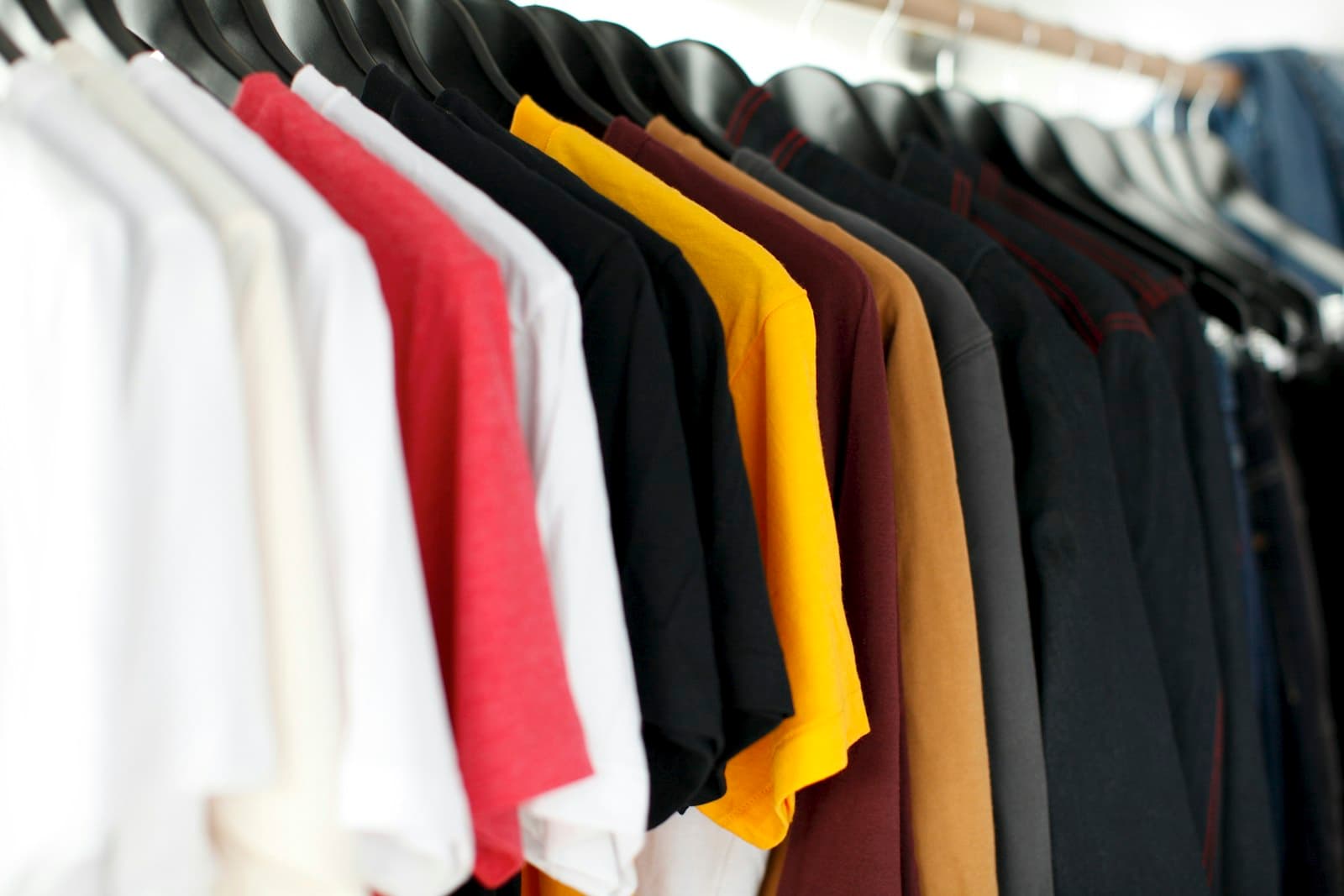A rack of plain tees in every colour — fabric weight, drape, and finish